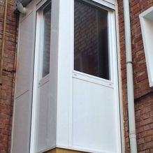 Aluminios Carsan esquina de una casa con ventanas de vidrio y luz apagada