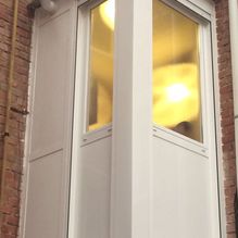 Aluminios Carsan esquina de una casa con ventanas de vidrio y luz encendida